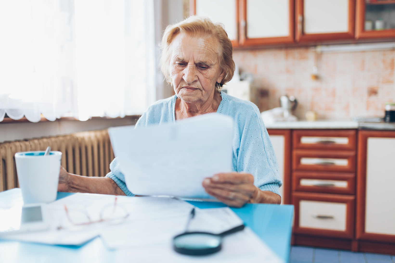 Elderly Woman Looking at Her Utility Bills